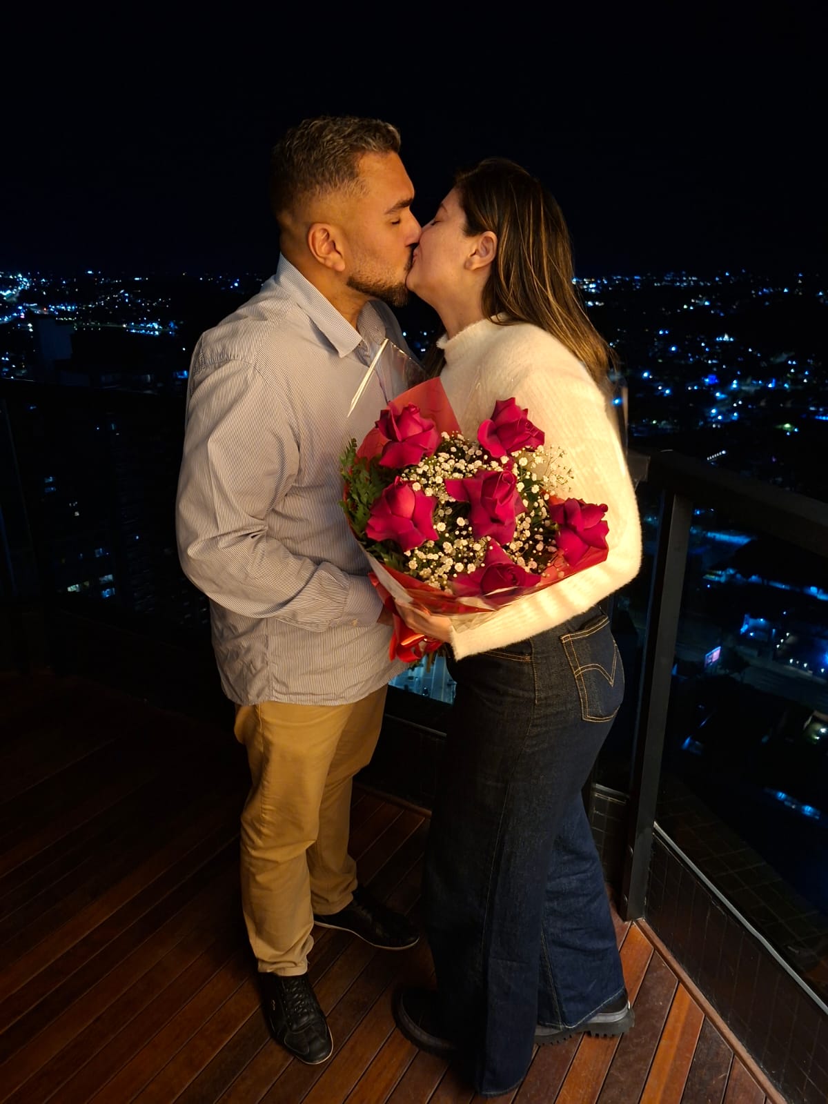 Beijo do casal com buquê de rosas